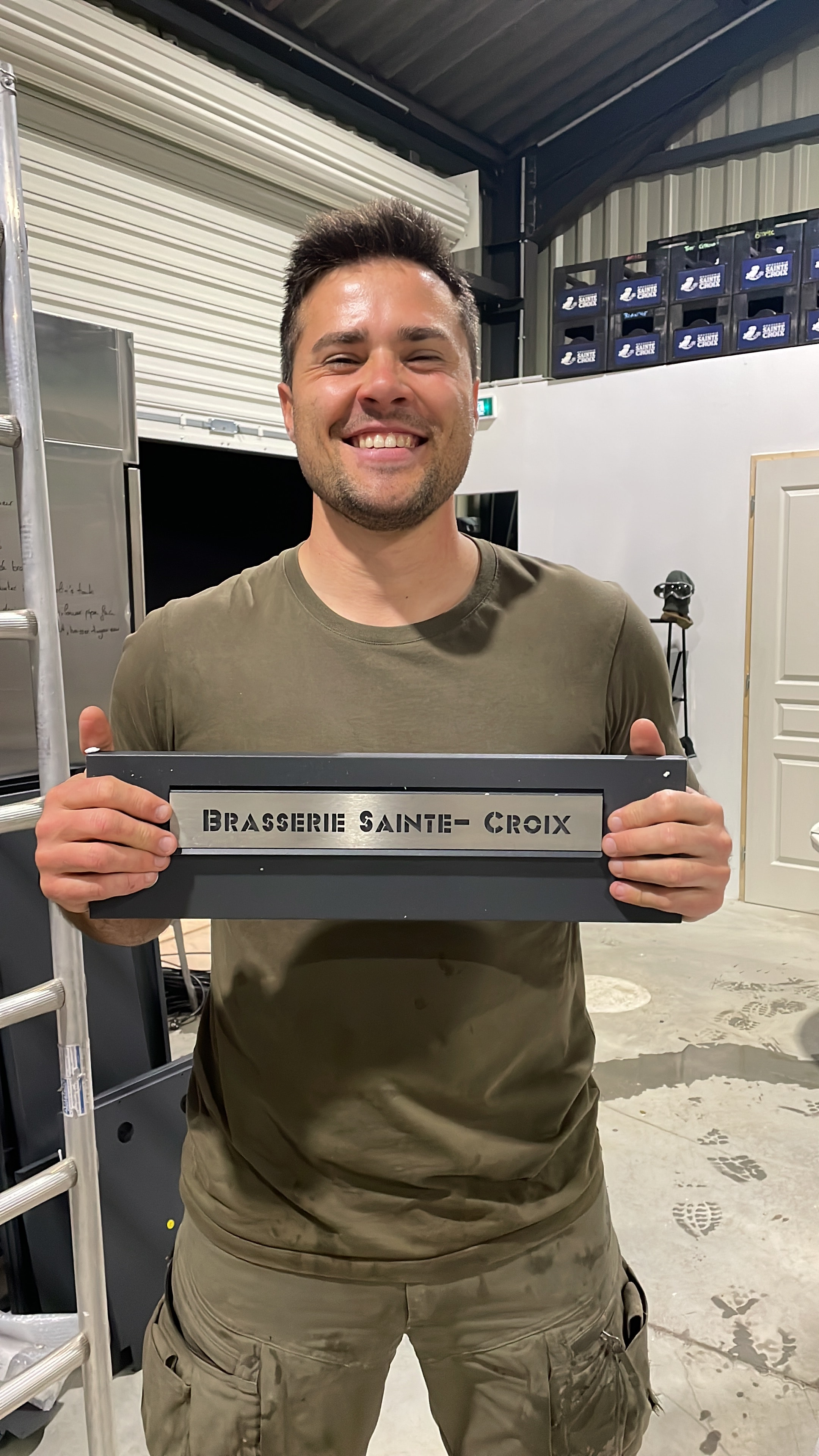Owner holding the Brasserie Sainte-Croix stencil plate